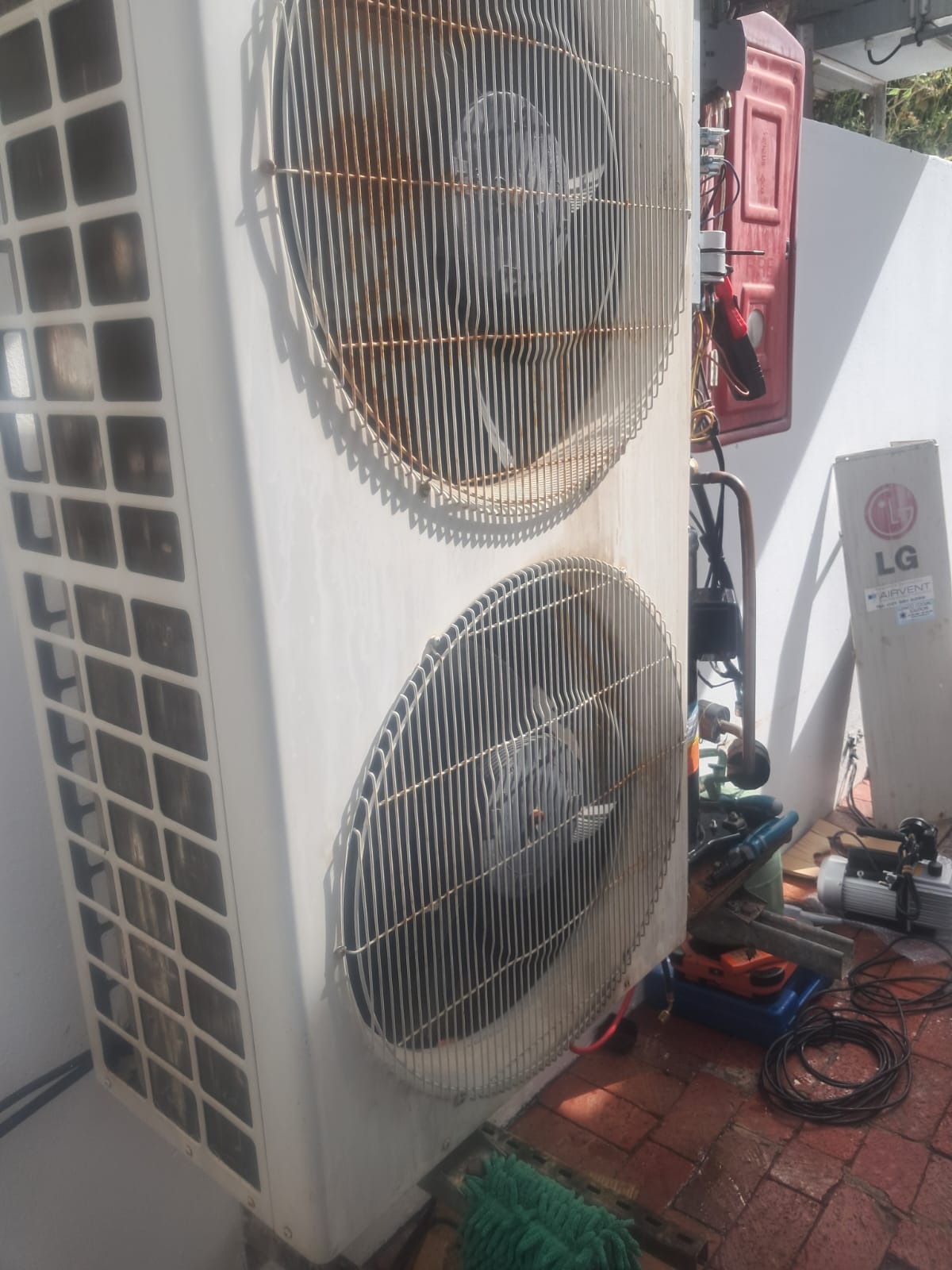 Large twin-fan outdoor air-conditioning condensing unit during compressor service