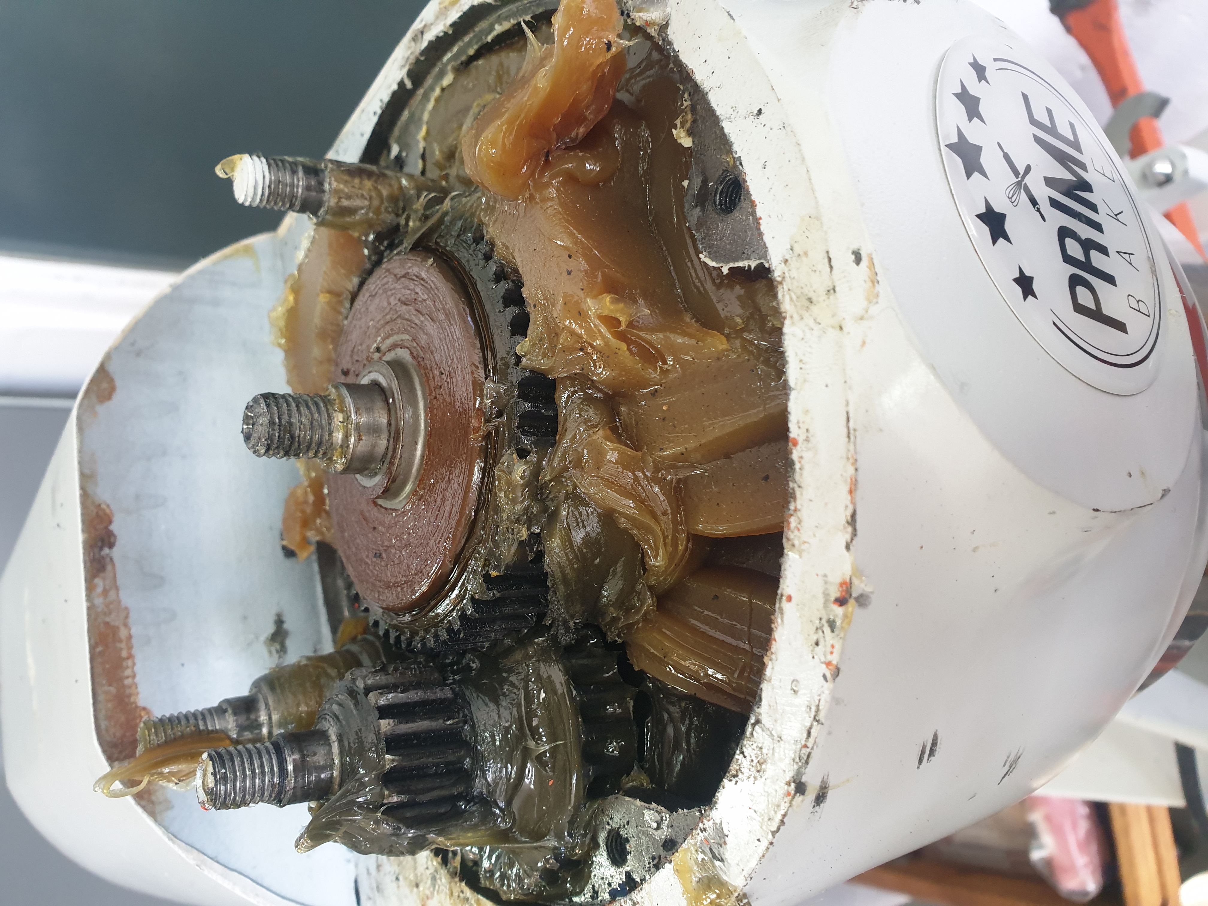 Commercial cake mixer stripped for rebuild with parts and mechanical areas exposed