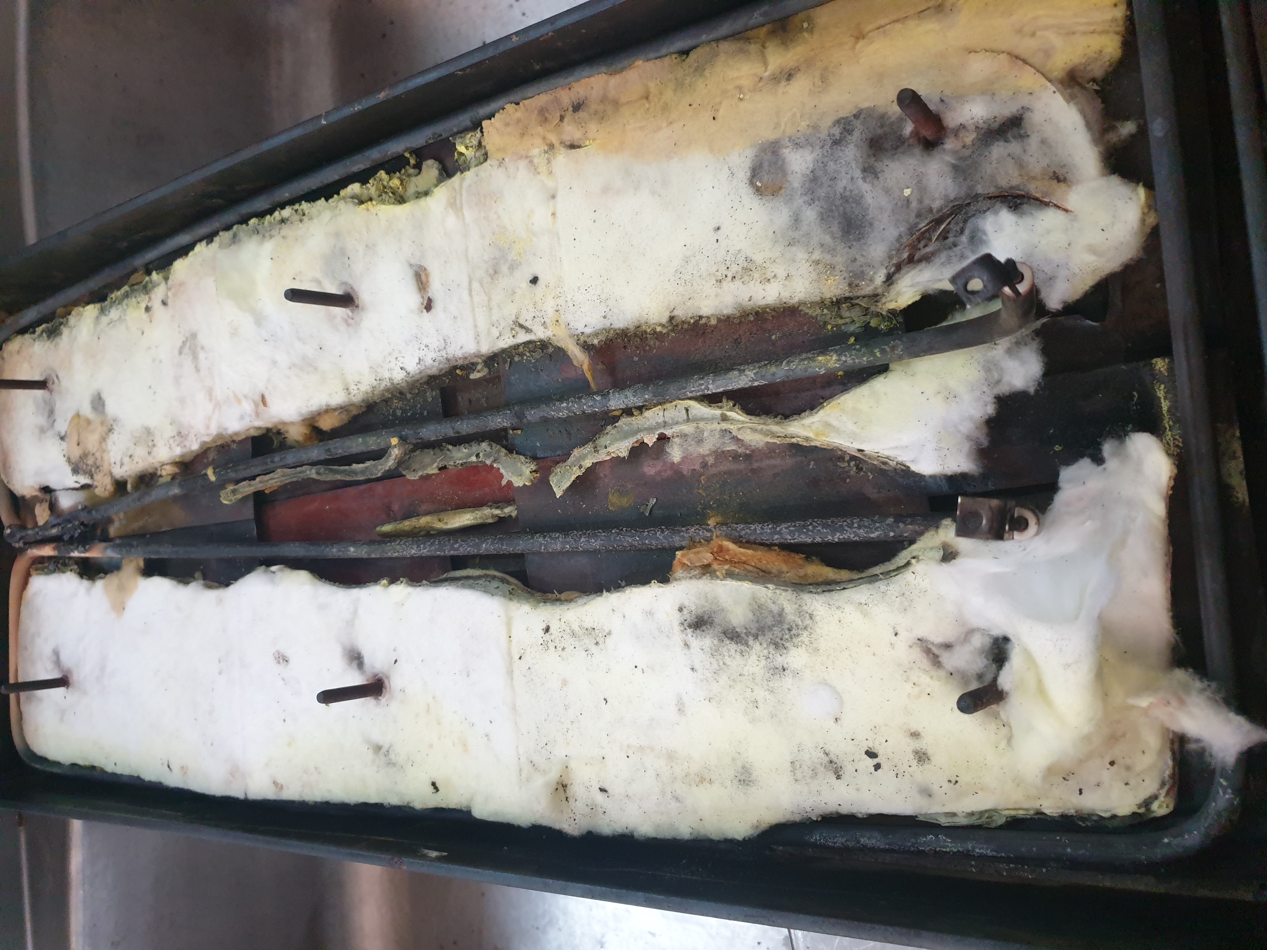 Commercial flat-top griddle with insulation and heating elements exposed