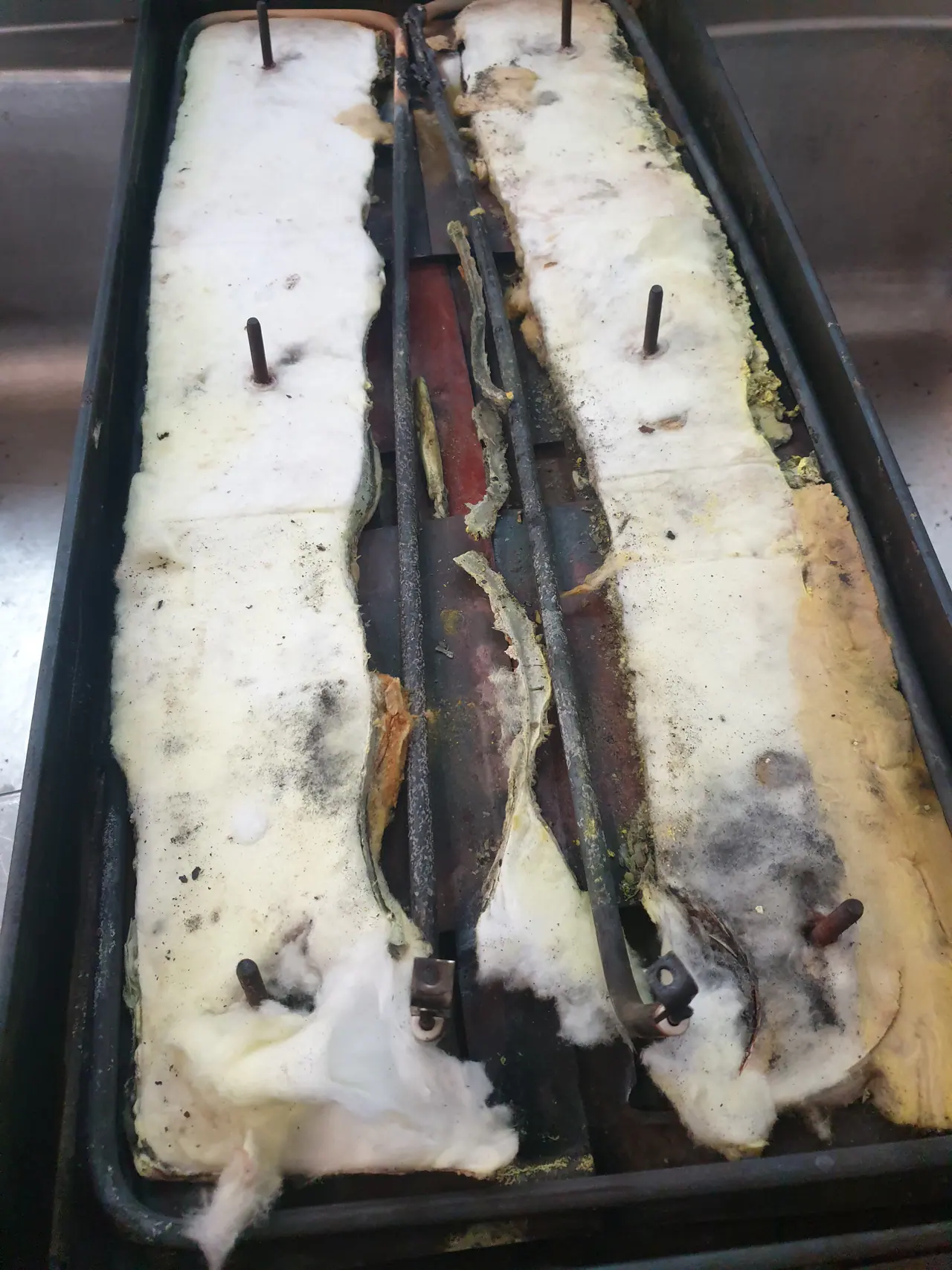 Commercial flat-top griddle with insulation and heating elements exposed