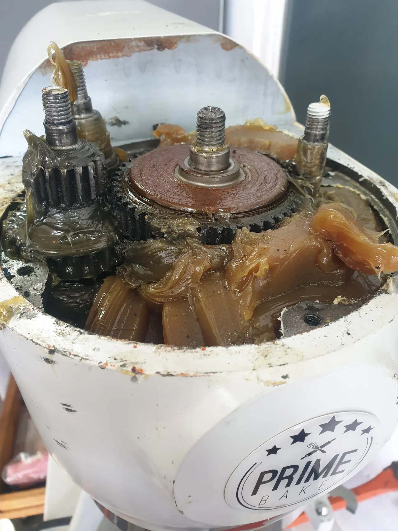 Commercial cake mixer stripped for rebuild with parts and mechanical areas exposed